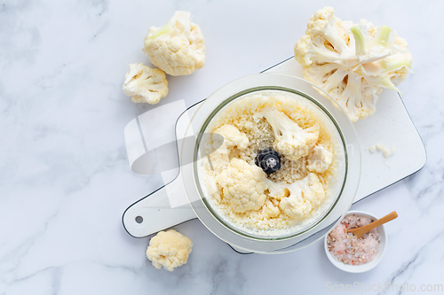 Image of Preparing  cauliflower rice in a food processor, cauliflower in a blender.