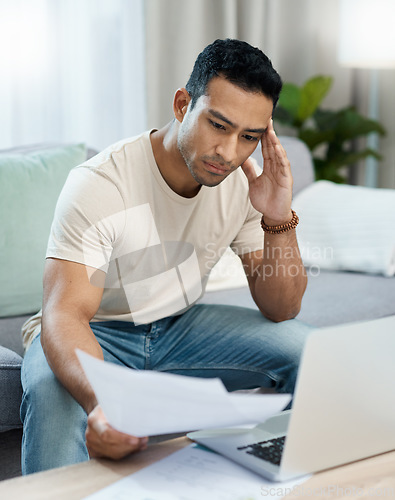 Image of Man, bills and headache on computer and sofa for finance mistake, debt review or taxes stress at home. Young and confused person with documents for budget fail, bankruptcy or inflation news on laptop