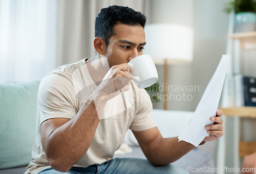 Image of Asian man, documents and drinking coffee in finance, expenses or checking bills on living room sofa at home. Male person with paperwork, latte or cup of tea and reading contract or insurance at house