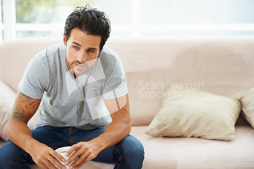 Image of Depression, thinking and sad man on a sofa with stress, anxiety or broken heart at home. Fail, crisis or male person in living room overthinking, disaster or lonely, worried or disappointed in house