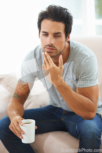 Image of Tea, thinking and home man relax, planning or brainstorming ideas, decision or remember memory on lounge couch. Coffee break, mindful and person thoughtful over daydream, problem solving or solution