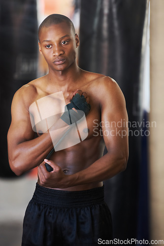 Image of Boxing, gym and black man wrapping hands with fitness, power and training challenge. Strong body, muscle workout and boxer in gym, athlete with confidence and getting ready for fighting competition.