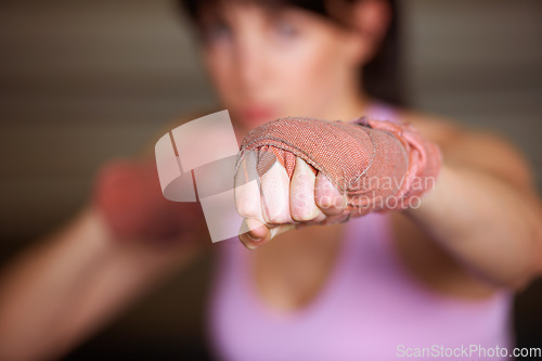 Image of Boxing, punch and hand of woman with fitness, power and fearless training challenge in gym. Strong body, muscle and blurred boxer, athlete or girl with fist up for confidence in competition fight.
