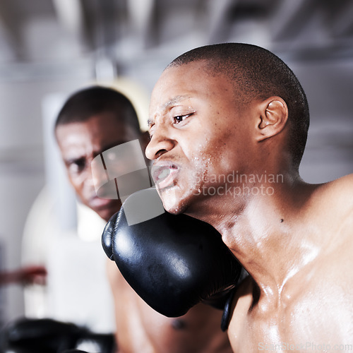 Image of Fight, black man and boxer with punch in ring together for fitness, power strike and training challenge. Strong body, hit in face and fearless athlete in gym with action and confidence in competition