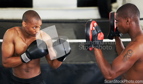 Image of Boxing, coaching and black man with personal trainer for fitness, power or training challenge. Strong body, sparring partner and boxer in gym with fist up, workout and confidence in competition fight