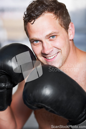 Image of Boxing, gloves and portrait of man with smile for fitness, power and training challenge in gym. Strong body, muscle and confidence, happy boxer or athlete with fist up and competition fight champion.