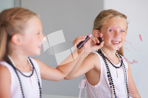 Image of Little girl, makeup and writing on mirror in bathroom for mess, naughty and bad behavior. Youth, kid and happy for drawing with lipstick, pink and cosmetics for beauty with smile for portrait in home