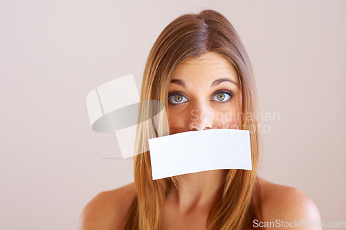 Image of Woman, mouth and sign for cover with mock up for silence in studio on white background. Portrait, female model and surprise in copy space for announcement, news or secret with placard, sign or poster