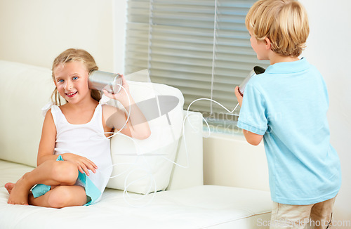 Image of Home, tin can and girl with boy, game and playing in the living room, happiness and fun on a couch. Apartment, siblings and children with weekend break, kids and relax with joy, smile or cheerful