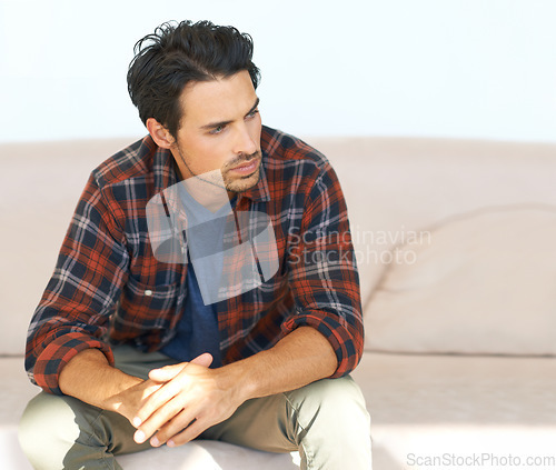 Image of Man, thinking and serious on sofa for idea, question and calm expression in living room of apartment or home. Person, face and thoughtful or contemplating on couch in lounge for chill on weekend