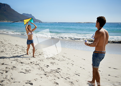 Image of Couple, kite playing and fun by beach in summer with love, care and support together on a holiday. Happy, vacation and date by the sea in Miami with freedom and travel by the ocean on a trip outdoor
