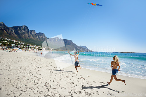 Image of Couple, running and summer with kite, beach and summer sunshine for vacation, freedom or play in air. Man, woman and speed to launch wind toys, bonding or holiday by sea on adventure in Naples, Italy