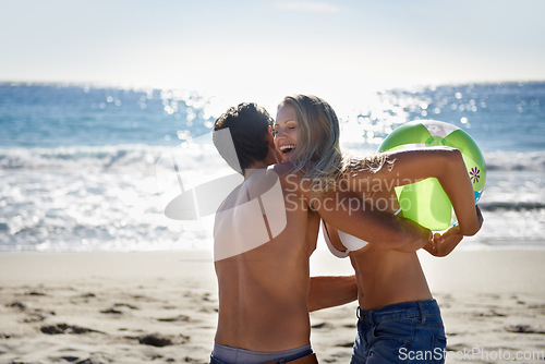 Image of Couple, ball playing and hug by beach in summer with love, care and support together on a holiday. Happy, vacation and date by the sea in Miami with freedom and travel by the ocean on a trip outdoor