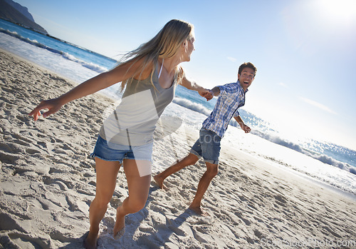 Image of Couple, playing and fun by beach in summer with love, care and support together on a holiday. Happy, vacation and date by the sea in Miami with freedom and travel by the ocean on a trip outdoor