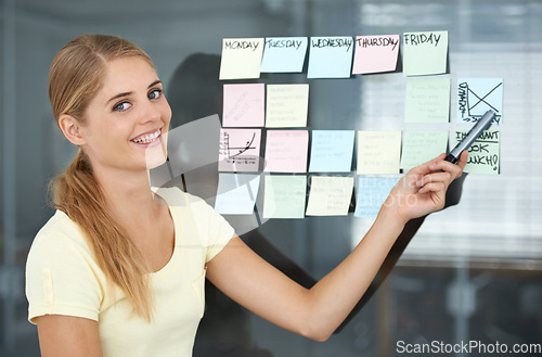 Image of Woman, pointing and sticky notes on glass wall, graph and smile for seminar, creative and portrait. Presentation, strategy and office job for weekly schedule, workplace and financial audit report