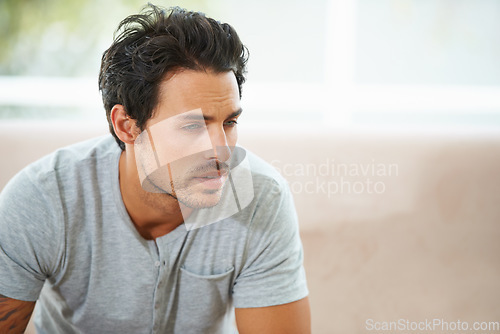 Image of Sad man, thinking and depression on a sofa with stress, anxiety or broken heart at home. Fail, crisis or male person in living room overthinking, disaster or lonely, worried or disappointed in house