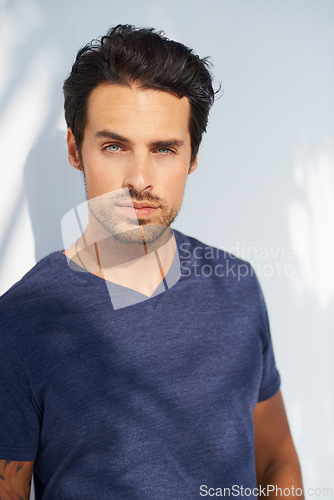 Image of Portrait, fashion and relax with a young man outdoor on a white background for casual style. Summer, natural and confident with a serious young model in a trendy blue tshirt or clothes outfit