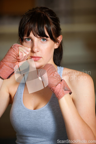 Image of Boxing, hands and portrait of woman with fitness, power and fearless training challenge in gym. Strong body, muscle and face of boxer, athlete or girl with fist up for confidence in competition fight