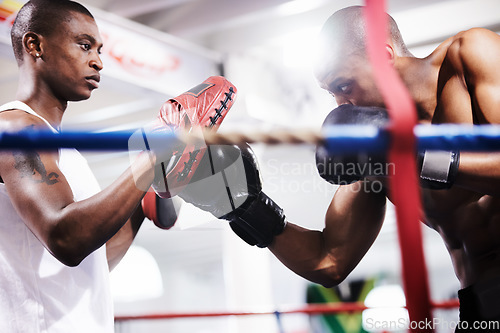 Image of Man, boxing and personal trainer in ring fight at gym for workout, exercise or indoor self defense training together. Male person, boxer or fighting sparing partner in sports, competition or practice
