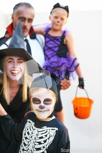 Image of Portrait, halloween and a family in costume for the tradition of trick or treat or holiday celebration. Mother, father and kids at a door in fantasy clothes for dress up on allhallows eve together