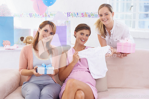Image of Women, baby shower and clothes in sofa, happy and grateful for support and presents. Pregnant lady, smiling and excited for pregnancy, motherhood and celebrating child with best friends in house