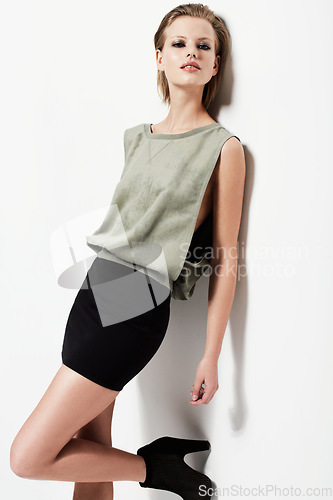 Image of Portrait, woman and clothes by leaning for white background with edgy fashion mockup in studio in Denmark. Female model, looking or serious expression with pose for trendy, funky and casual style