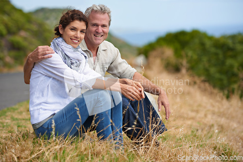 Image of Couple, face and happy in nature with relax, communication and peace for bonding, relationship or roadtrip. Mature, man and woman with smile, sitting and break outdoor with travel, vacation and trust