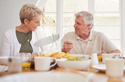 Image of Breakfast, talking and lunch with senior couple, eating and happy together in a home. Love, support and care on a dining room with a smile and food with bonding in the morning with fruit in house