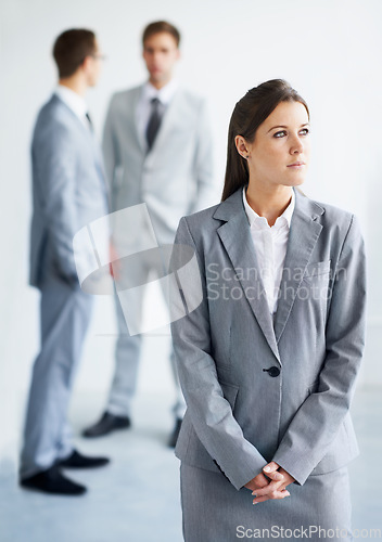 Image of Businesswoman, serious and thinking for future in law career, standing and ready for job. Worker, corporate attorney in suit and professional in workplace, colleagues in background and confident