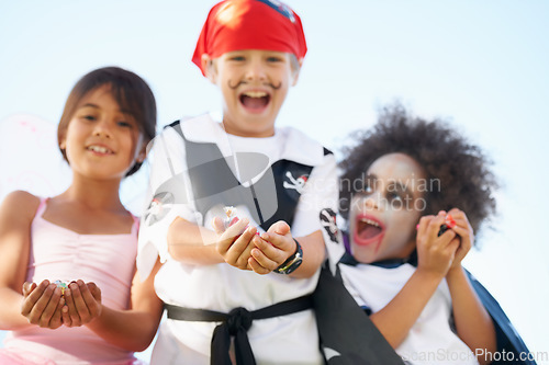 Image of Children, halloween and costume or hands for candy asking as dracula dress up, fairy or pirate role play. Friends, group and happy for sweet dessert or celebration for fantasy, fun on sky background