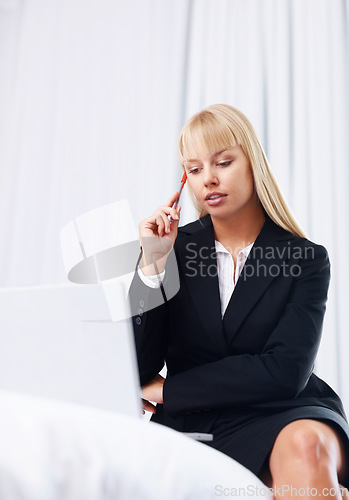 Image of Businesswoman, thinking or reading with laptop in home office for feedback, report or message. Female consultant, information and technology with, hand, pen or notes for review of online document