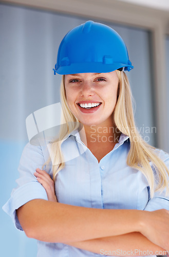 Image of Architecture, portrait of happy woman with confidence and helmet for safety on construction site. Civil engineering, project management and property development, female contractor with arms crossed.