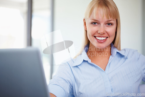 Image of Portrait, smile and happy woman in office with laptop, market research or online website review. Businesswoman at desk with technology, professional career and administration job at startup agency.