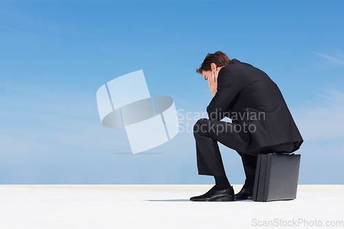 Image of Depression, sky and business man sad, burnout or stress over corporate mistake, company disaster or agency fail. Mental health risk, mockup space and back of professional person sitting on briefcase