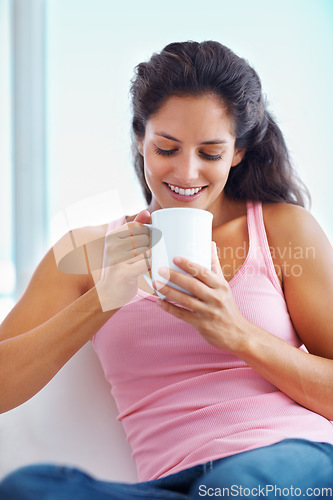 Image of Relax, coffee break and woman in house for thinking, resting or enjoying peaceful moment, day off or me time. Face, smile and female person in a living room with tea, calm or weekend freedom chilling