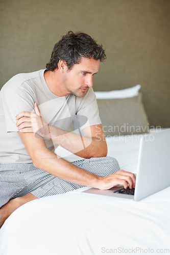 Image of Freelancer, man in bedroom and laptop to work from home, smiling and sitting in bed for freelance job. Technology, Entrepreneur and remote worker for online job, company and marketing projects