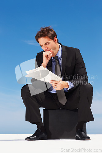 Image of Yawn, newspaper and businessman reading information sitting by the outdoor blue sky with burn out. Tired, exhausted and sleepy professional young male person in a suit sitting with magazine report.