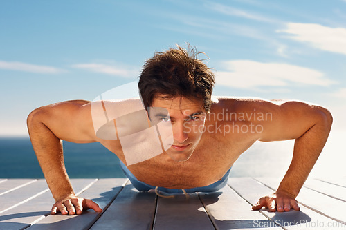 Image of Young man, push up and portrait with workout for health body, fitness and exercise by sky background. Model, face and commitment with glow for wellness and muscle training on plank on summer vacation