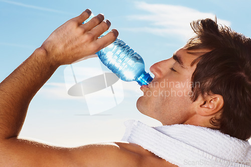 Image of Young man, drinking water bottle or towel for workout with health body, fitness and vacation. Model, thirsty or natural glow with h2o drink for hydration or post cardio exercise by sky background