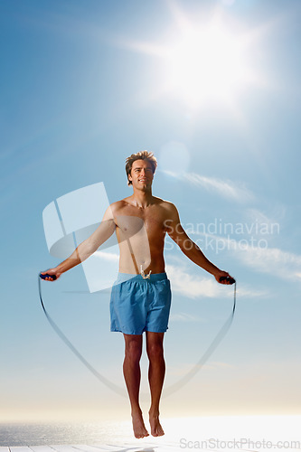 Image of Man, shirtless or rope skipping for fitness in summer workout, muscle or happy on vacation. Model, smile or training for natural glow of sport, cardio exercise or sunshine holiday by sky background