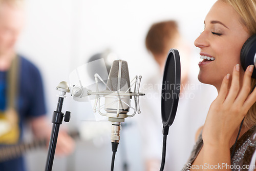 Image of Music studio, woman singer with microphone and headphones for performance with talent. Recording, art and girl musician singing on live streaming, song for record label and professional audio sound.