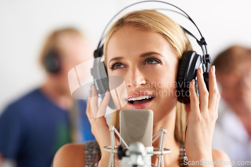 Image of Music, art and woman with microphone, headphones and band performance with talent. Recording studio, singing and happy girl musician live streaming voice for record label, sound and audio broadcast.