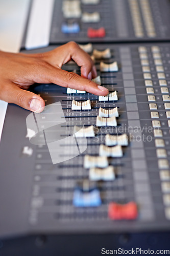 Image of Recording studio, hand and mixing on sound board with dj, technology and media on desk. Music, editing or person with equipment for audio, production and moving switch on console for radio or song