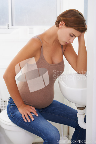 Image of Vomiting, pregnant woman and morning sickness in bathroom, nausea and uncomfortable. Mirror reflection, moody and frustrated with illness, pregnancy and struggling with migraine pain on sink