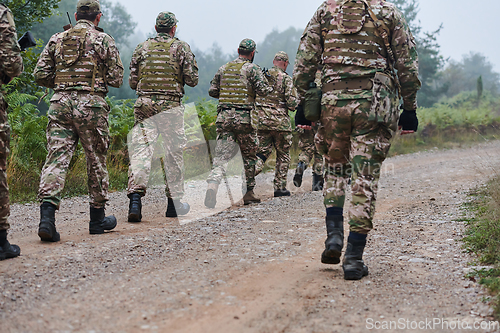 Image of An elite military unit, led by a major, confidently parades through dense forest, showcasing precision, discipline, and readiness for high-risk operations