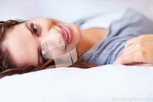 Image of Smile, happy and portrait of woman on bed for rest, daydreaming and comfortable at home. Blanket, relax and face of person in bedroom lying, nap and wake up for health, wellness or calm in morning