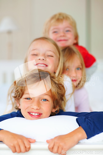 Image of Portrait, smile or love with brother and sister sibling children on a bed in their home together. Family, happy or bonding with young boy and girl kids in the bedroom of an apartment on the weekend