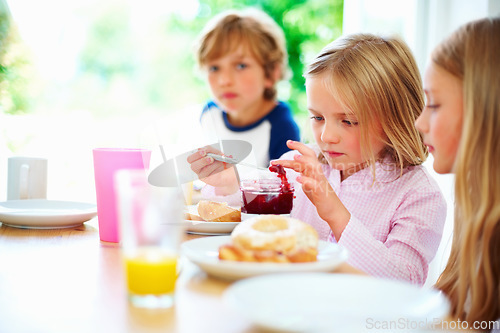 Image of Family, morning and breakfast jam, children and meal for nutrition, orange juice and bagel. Brother, sisters and enjoying food together for hunger, health and energy for home weekend activities