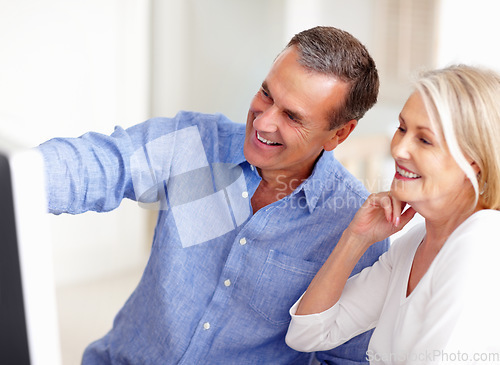 Image of Talking, senior or happy couple on laptop for email, social media or streaming subscription in home. Research, booking vacation or mature people on computer website or internet network in living room