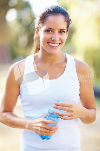 Image of Portrait, fitness or happy woman with water in a park for running, wellness or training with bokeh. Sports, liquid and face of female runner in nature for exercise with positive mindset and energy